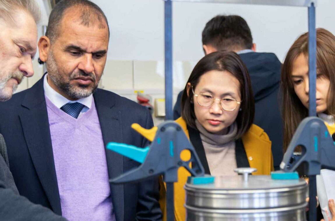 Group of people being explained an ASM test sieve shaker